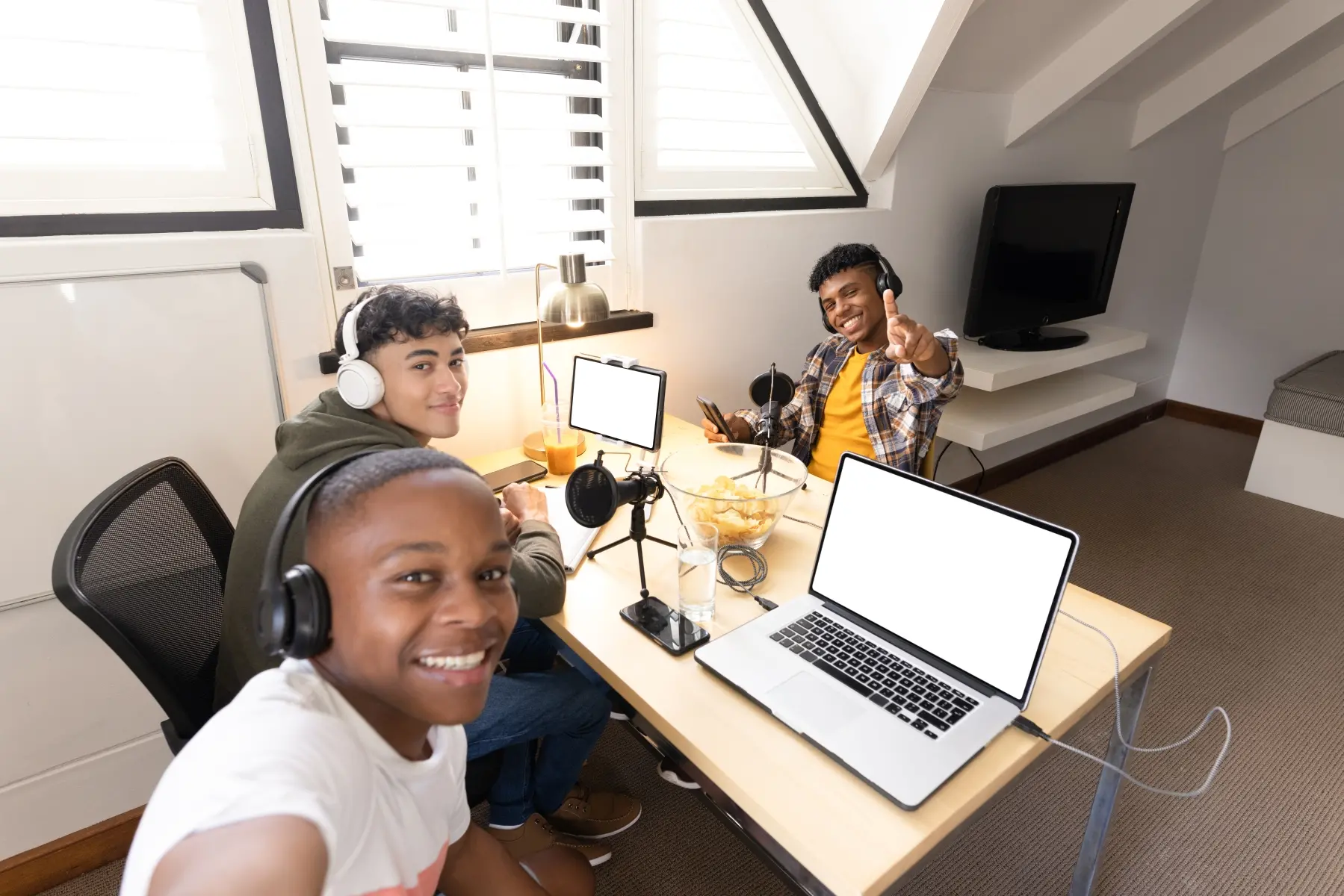 Tre tonårsgrabbar vid sina datorer 