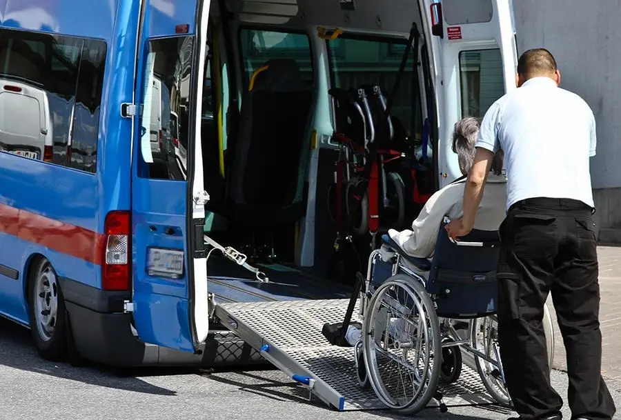 bild på en man som skjuter upp en rullstol i en buss