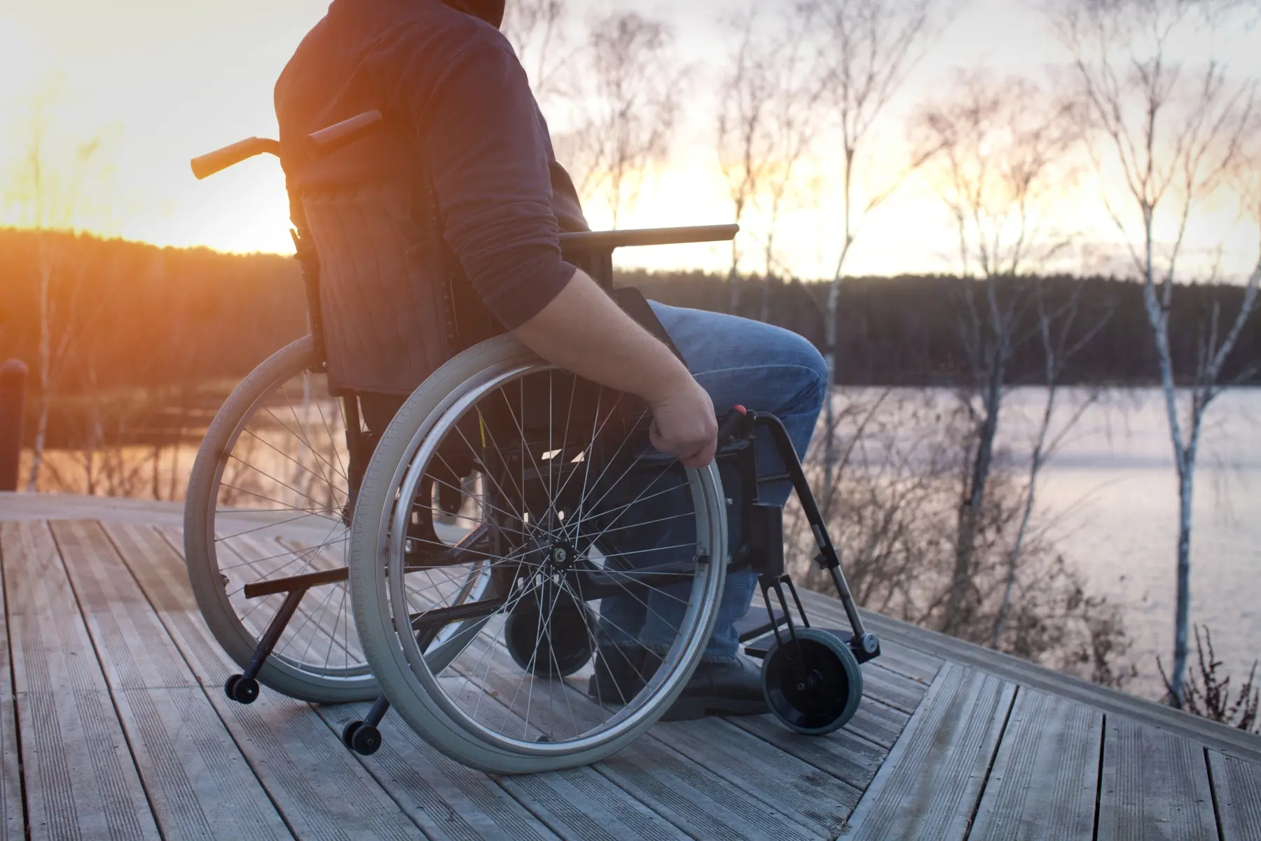 Funktionsnedsatt person i rullstol tittar ut över en sjö