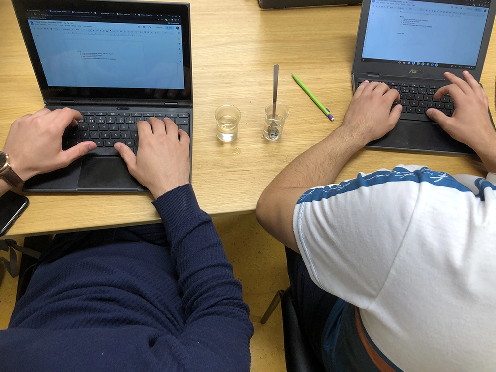 två ungdomar vid varsin dator